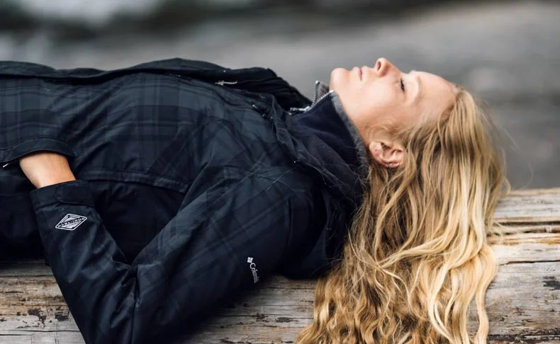 woman sleeping and relaxing on a wooden bench